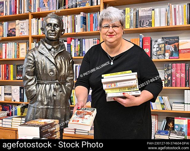 PRODUCTION - 18 January 2023, Brandenburg, Bernau: Sylvia Pyrlik, bookseller and owner of the ""Schatzinsel"" bookstore, stands next to a figure by playwright...