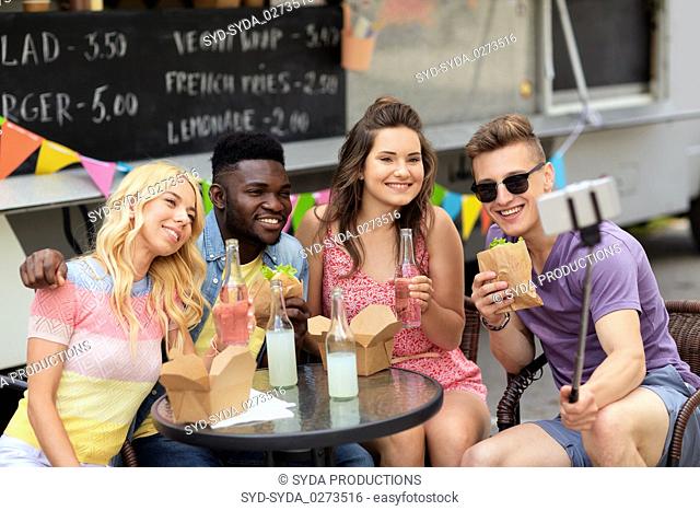 happy young friends taking selfie at food truck