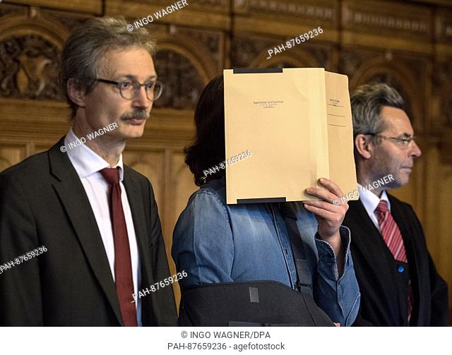 The defendant in a murder trial hides his face behind a folder in the hearing room of the regional court in Bremen, Germany, 31 January 2017