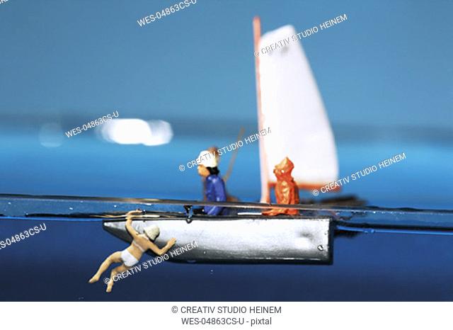 Two male figurines in boat, woman in water, close-up