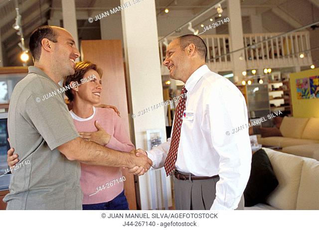 Couple and salesman in furniture shop