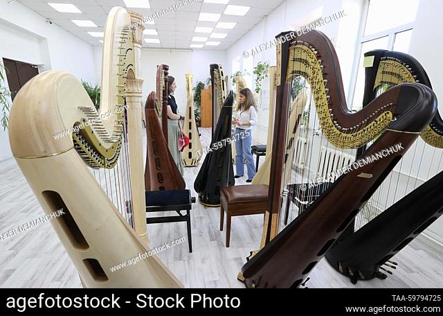 RUSSIA, ST PETERSBURG - JUNE 13, 2023: Visitors look at harps in an outlet shop at the Resonance Harps musical instrument factory