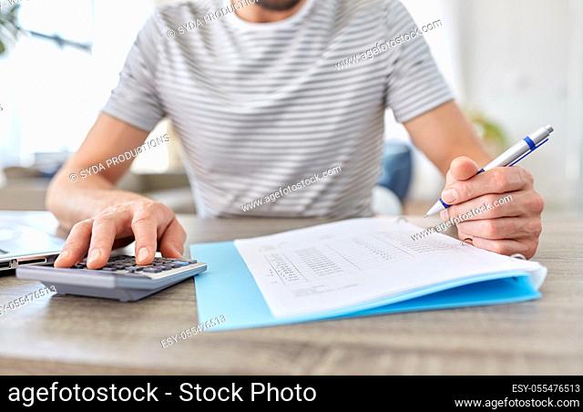 man with files and calculator works at home office