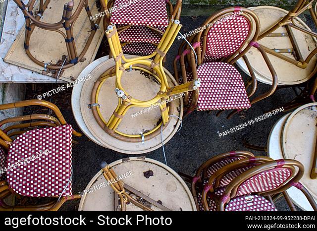 24 March 2021, Saxony-Anhalt, Quedlinburg: Chairs and tables of a café are piled up on the side of a street. Because of the spread of the coronavirus