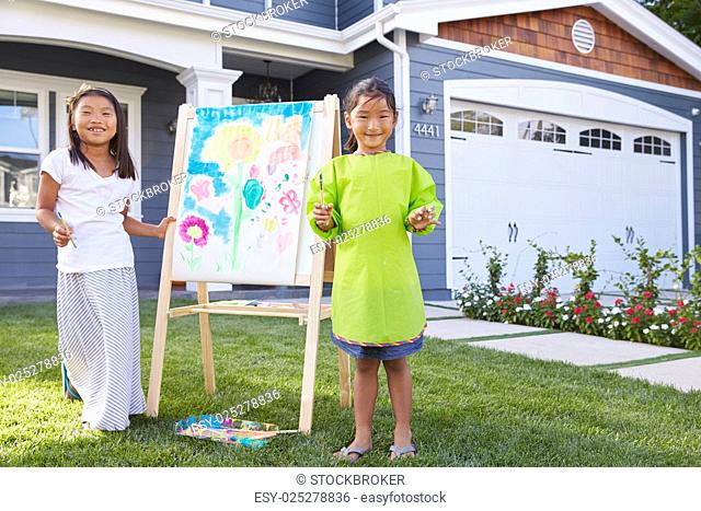 Portrait Of Two Girls Painting Picture In Garden