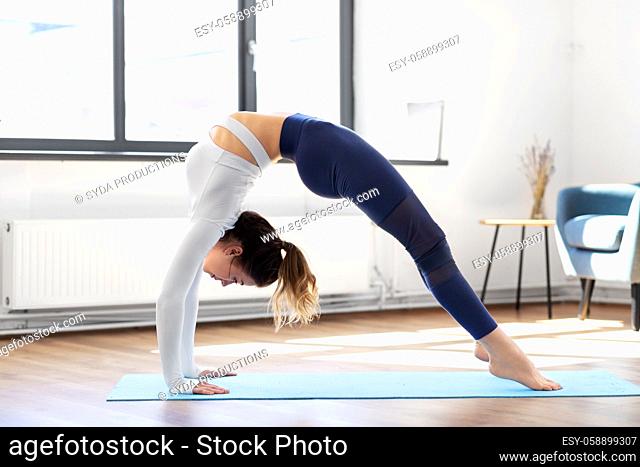 young woman doing bridge pose at yoga studio