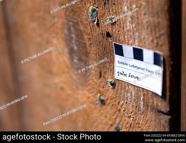22 February 2023, Mecklenburg-Western Pomerania, Ludwigslust: Markers of monument preservation hang on an exposed wooden wall in one of the rooms of Ludwigslust...