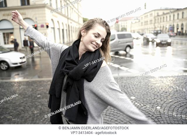 carefree woman at street in city, rainy weather. Munich, Germany