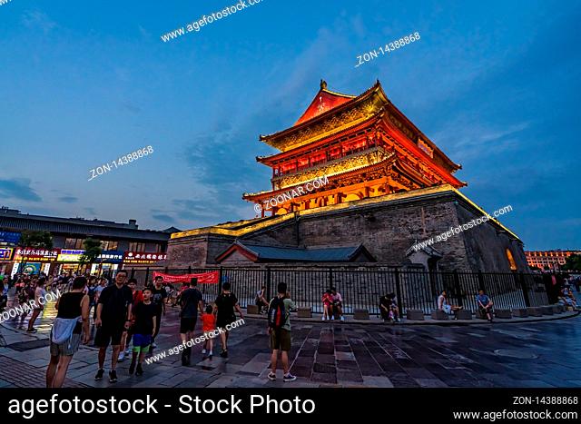 Xian, China - July 2019 : Tourists walking in front of the Bell Drum Tower beautifully lit and illuminated at night, Shaaxi Province, Central China