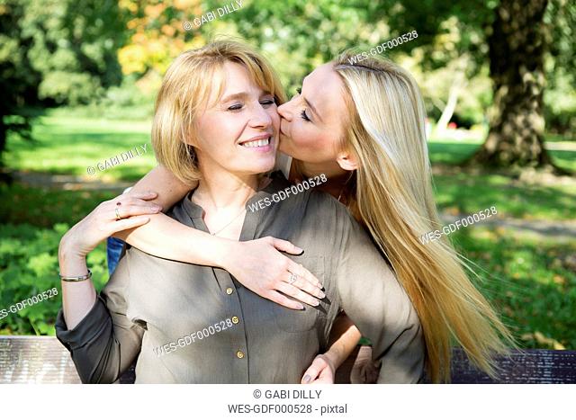 Adult daughter kissing mother in park