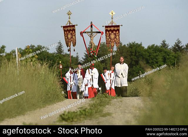 dpatop - 22 May 2020, Baden-Wuerttemberg, Weingarten: Dean Ekkehard Schmid (centre), the Holy Blood Rider, holds the Holy Blood relic in his hand while riding a...