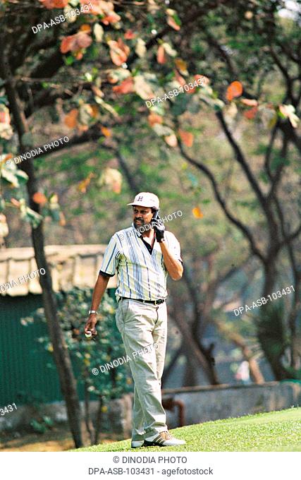 South asian indian cricketer and Former Indian cricket captain Kapil Dev talking on cell phone and playing golf at Bombay Presidency Golf Club (BPGC) in Chembur...