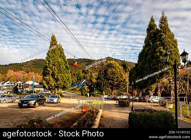BARILOCHE, ARGENTINA, JUNE 19, 2019: Red cable car carrying passengers to the top of snowy mountains seen in the background