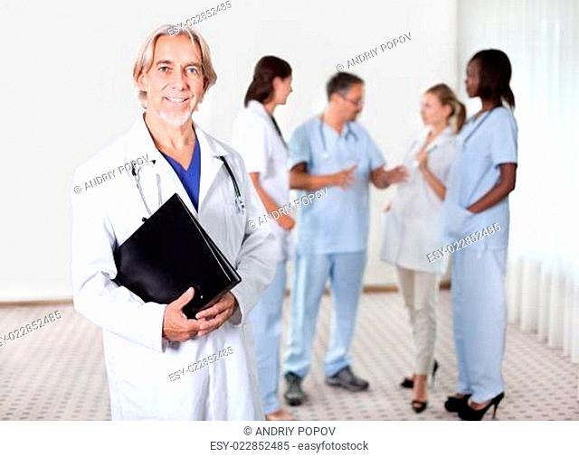 Mature doctor holding files