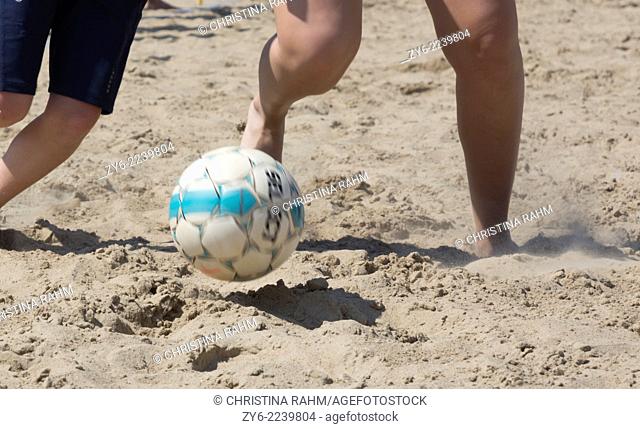 Closeup of legs, sand and soccer ball in action. Ahus Beach Soccer tournament 2014