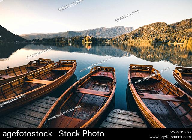 Amazing landscape of Lake Bled in Slovenia - traditional Pletna boats at sunrise background. Lake bled is a famous place and popular European travel destination