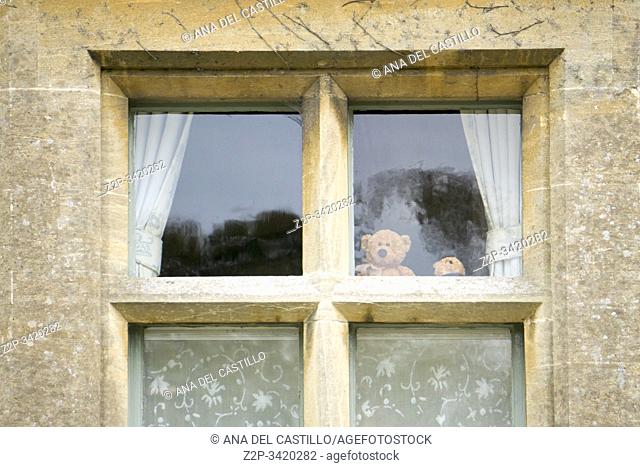 Lower Slaughter village Gloucestershire The Cotswolds England UK on October 12, 2019. Teddy bear in window