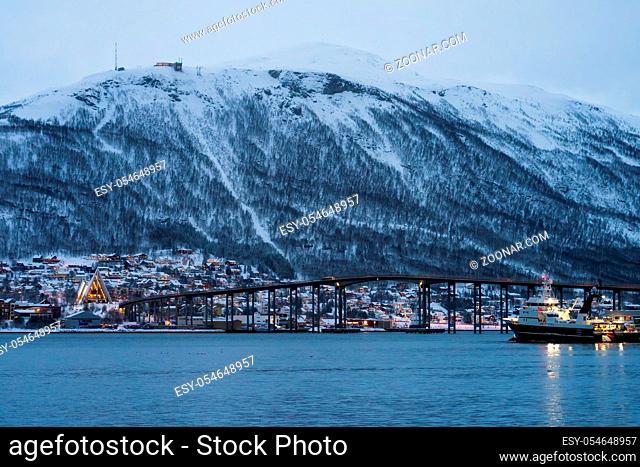 Port and harbour with famous Tromso Bridge across Tromsoysundet strait in the background, Northern Norway