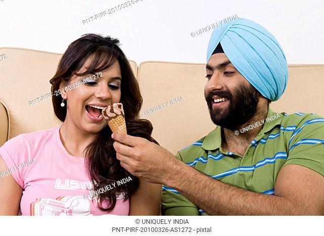 Sikh man feeding ice cream to his wife