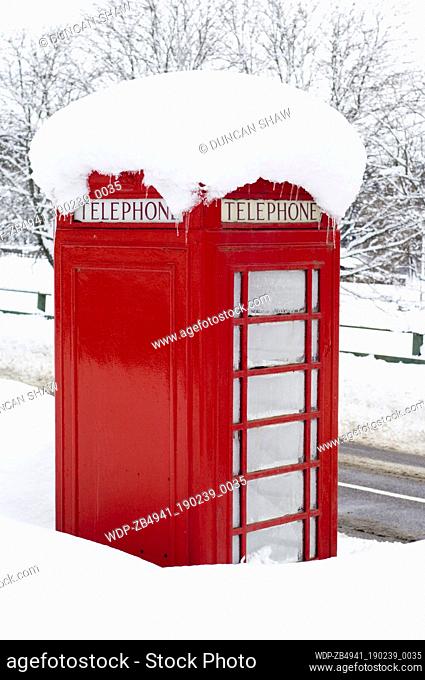 Red telephone box in deep snow by the A93 roadside in the village of Crathie, outside Balmoral Castle