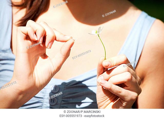Woman counting petals of flower