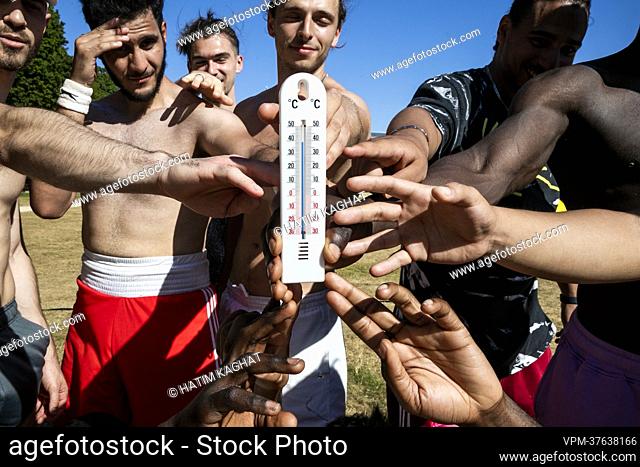 Illustration picture shows youngsters grabbing a thermometer indicating 40 degrees during the heath wave in Brussels on Tuesday 19 July 2022