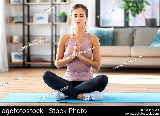 woman doing yoga in lotus pose at home