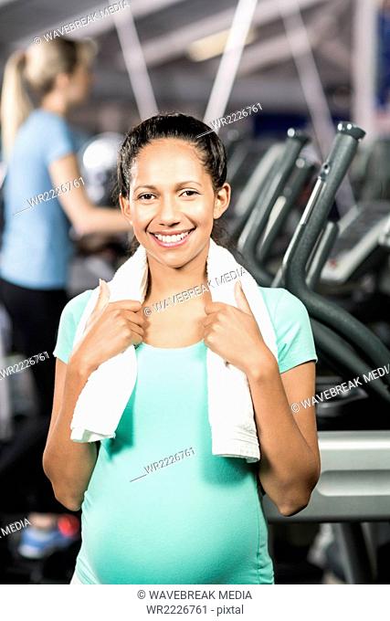 Smiling pregnant woman with towel around neck