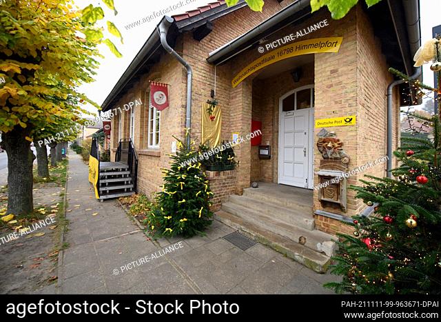 11 November 2021, Brandenburg, Fürstenberg/Havel/Ot Himmelpfort: Decorated fir trees stand next to the entrance to the Christmas post office