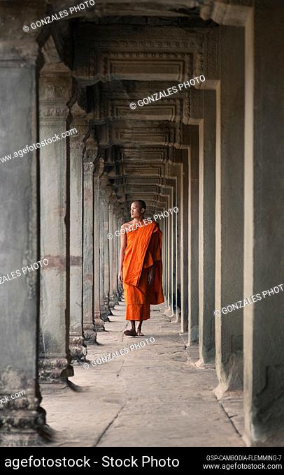 Siem Reap, Cambodia - January 19, 2011: A monk is wearing a orange robe and walking in the Angkor Wat complex