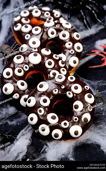 Donuts with chocolate icing decorated googly eyes on Halloween