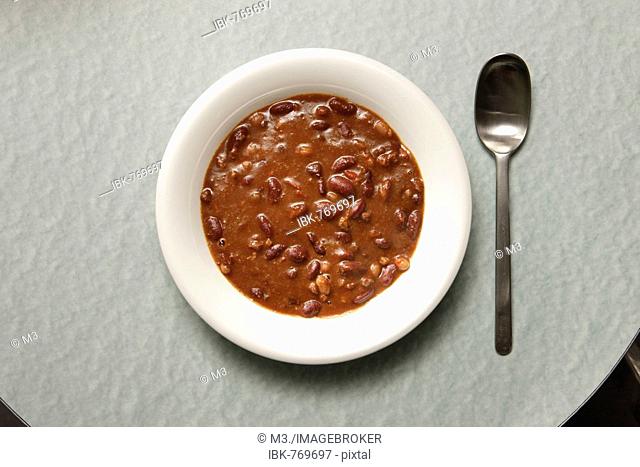 Spoon beside a plate of chili con carne