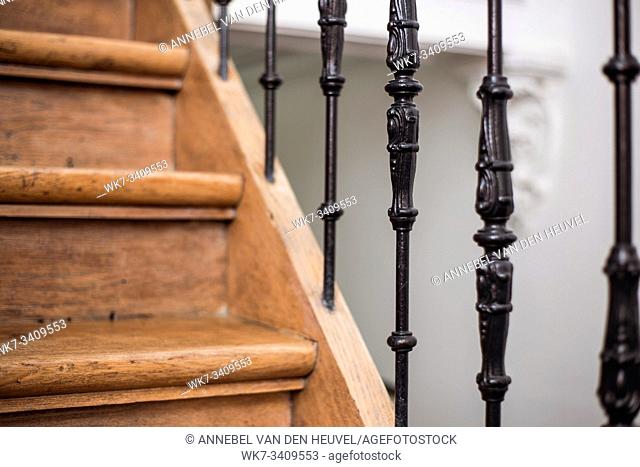 Staircase Handrailing in Old Historic Building. Interior Decor of Vintage Stairs with Metal Ornament and White Wall Background