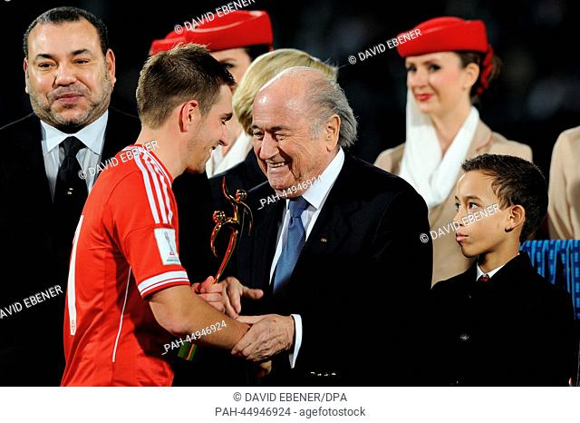 Philipp Lahm (C) receives his trophy for the best player of the tournament by King Mohammed VI of Morocco (L) and FIFA president Joseph Sepp Blatter after...