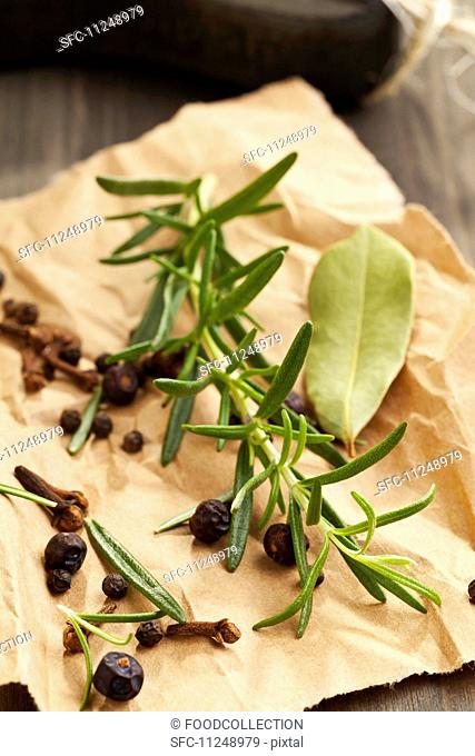 A mixture of wild spices: rosemary, pepper, juniper berries, a bay leaf and cloves