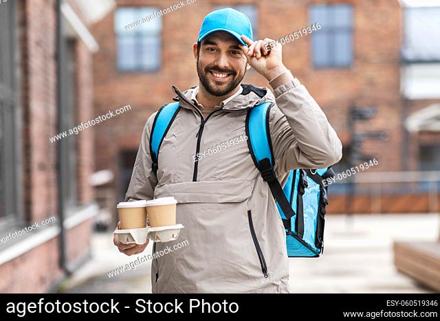 happy delivery man with thermal bag and coffee