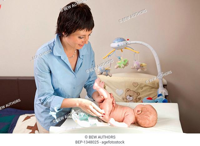 Mother changing her baby's nappy