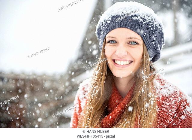 Portrait of smiling young woman in heavy snowfall