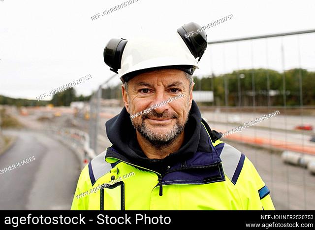Portrait of male engineer in reflecting clothing at building site