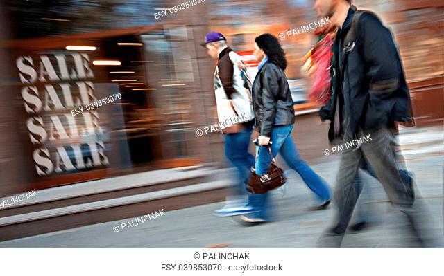 Group of people go to the store on sale. Intentional motion blur