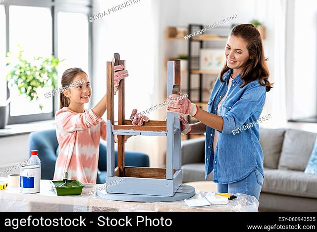 mother and daughter sanding old table with sponge