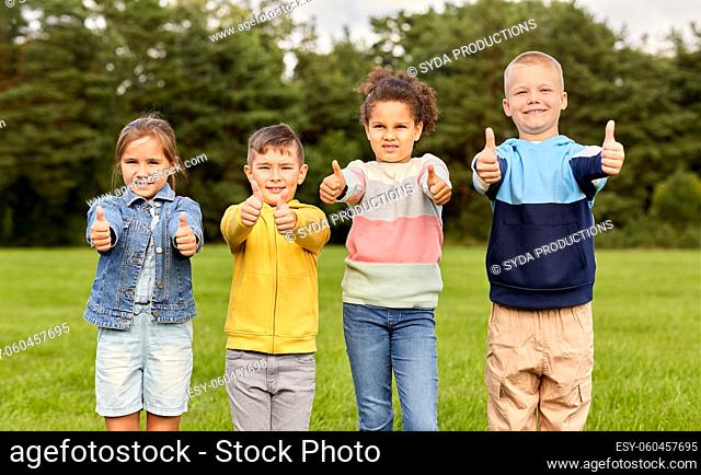 happy children showing thumbs up at park