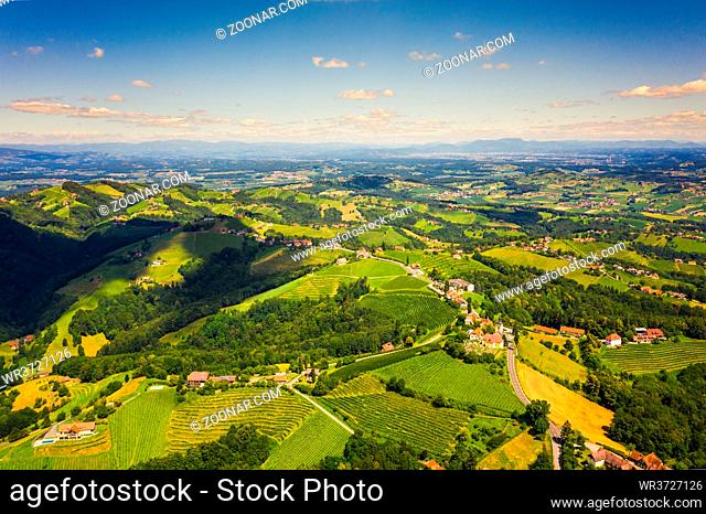 Aerial view of green hills and vineyards with mountains in background. Kitzeck im Sausal, Austria