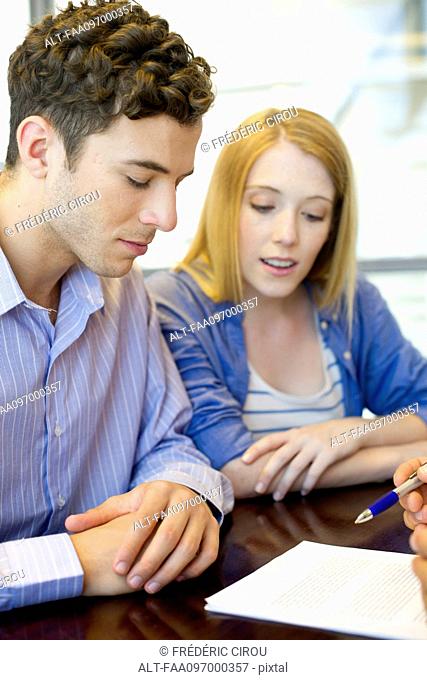 Clients reviewing contract with advisor