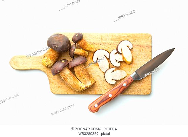 Sliced boletus mushrooms on cutting board and knife. Tasty food mushrooms