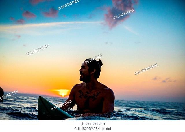 Surfer gliding in sea at sunset, Pagudpud, Ilocos Norte, Philippines