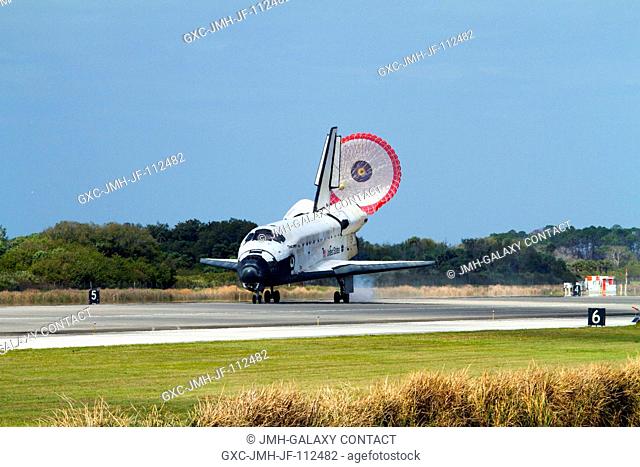 Space shuttle Discovery's drag chute is deployed as the spacecraft rolls toward wheels stop on Runway 15 at the Shuttle Landing Facility at NASA's Kennedy Space...