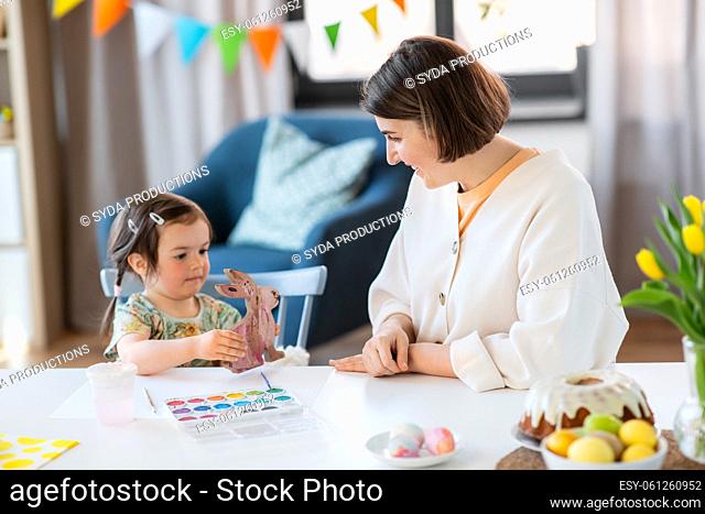 mother with child coloring easter bunny at home