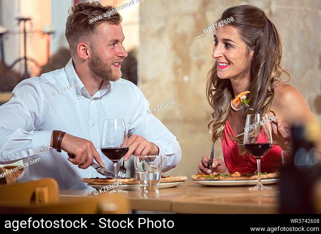 Portrait of a happy young couple dining together at restaurant