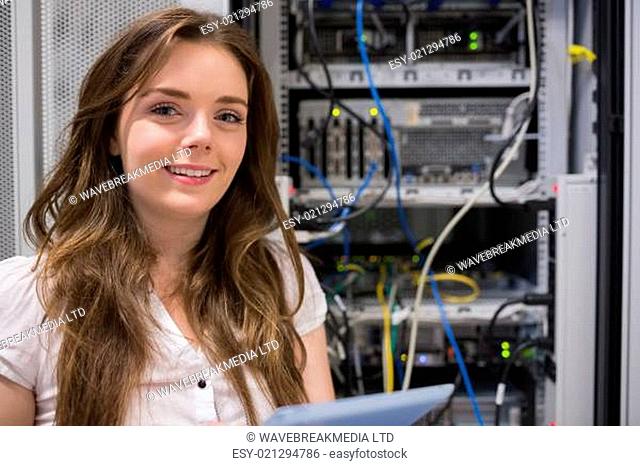 Smiling woman standing in front of servers in data storage